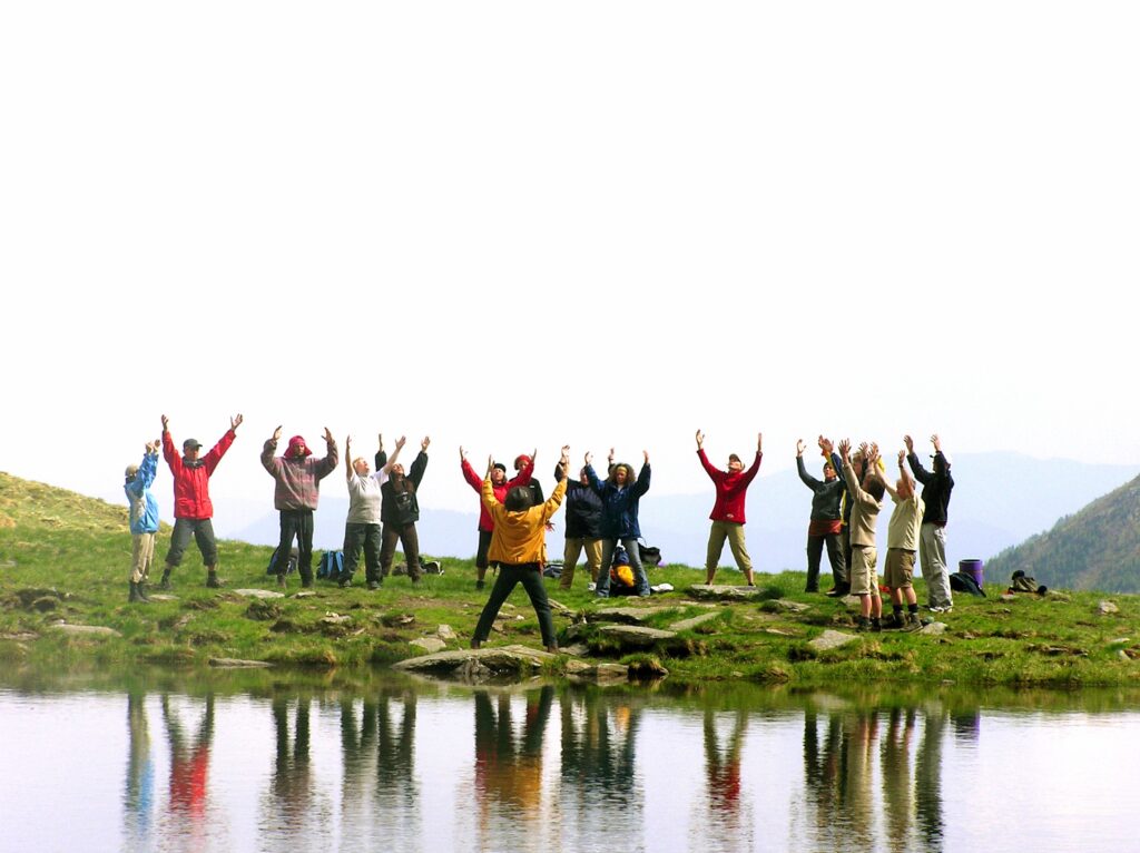 The people raising their hands at the lake